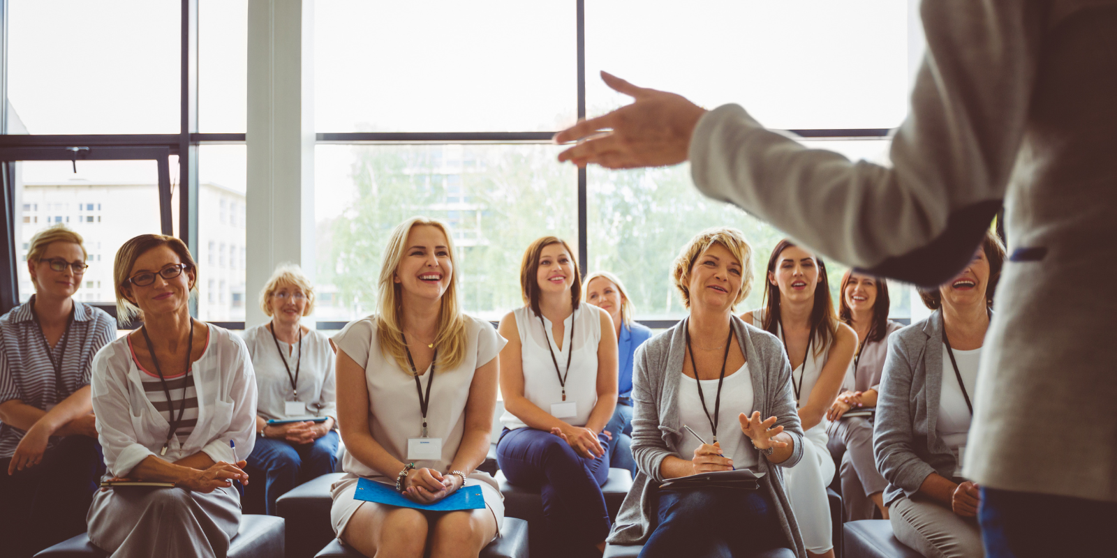 une femme qui donne une conférence à plusieurs femmes